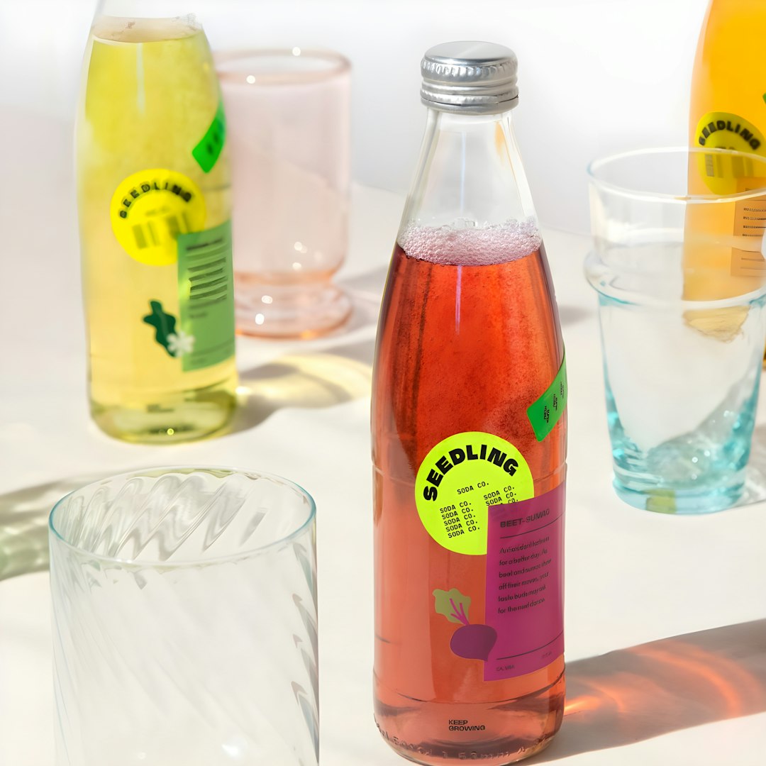 Bottles of colorful drinks with glasses